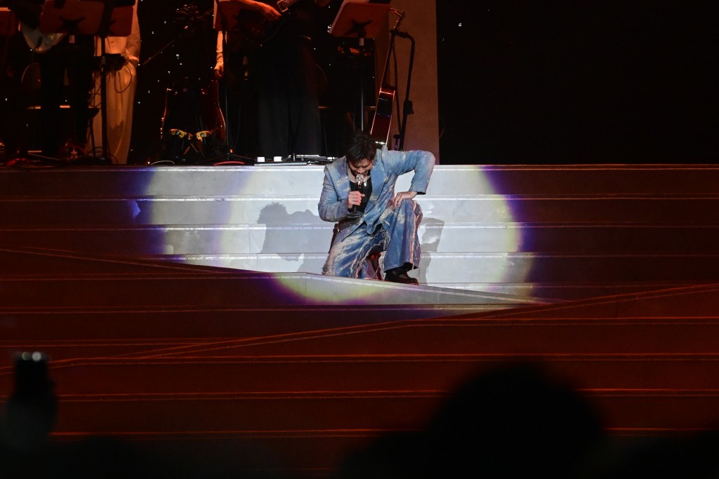 陈柏宇跌倒后跪在地上继续唱。