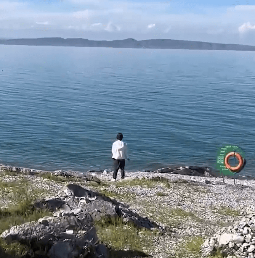 男游客翻越护栏，疑似在青海湖边小便，引发关注。