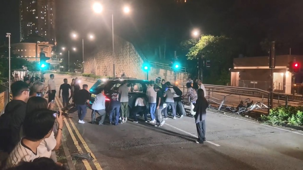大約有30名熱心市民與警員合力將私家車推回慢線,讓後方的車輛可以通過。fb「屯門公路塞車關注組」Cherubim Cole片段截圖 大約有30名熱心市民與警員合力將私家車推回慢線,讓後方的車輛可以通過。fb「屯門公路塞車關注組」Cherubim Cole片段截圖
