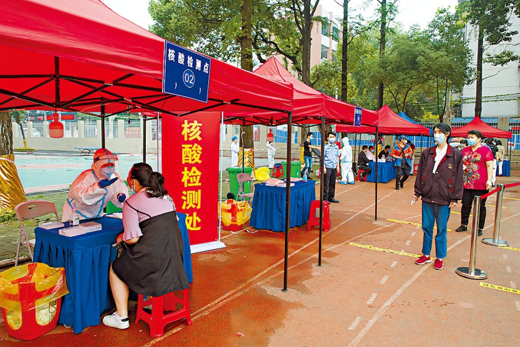 武漢工作人員日前對市民進行核酸檢測。