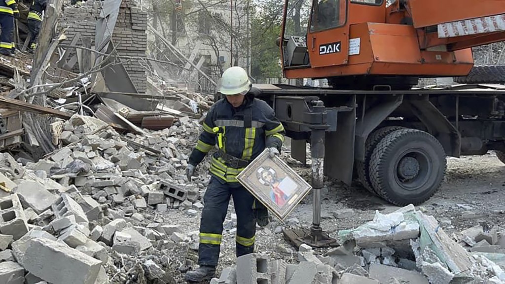 烏克蘭一名救援人員在扎波羅熱被砲擊的現場展開工作。AP