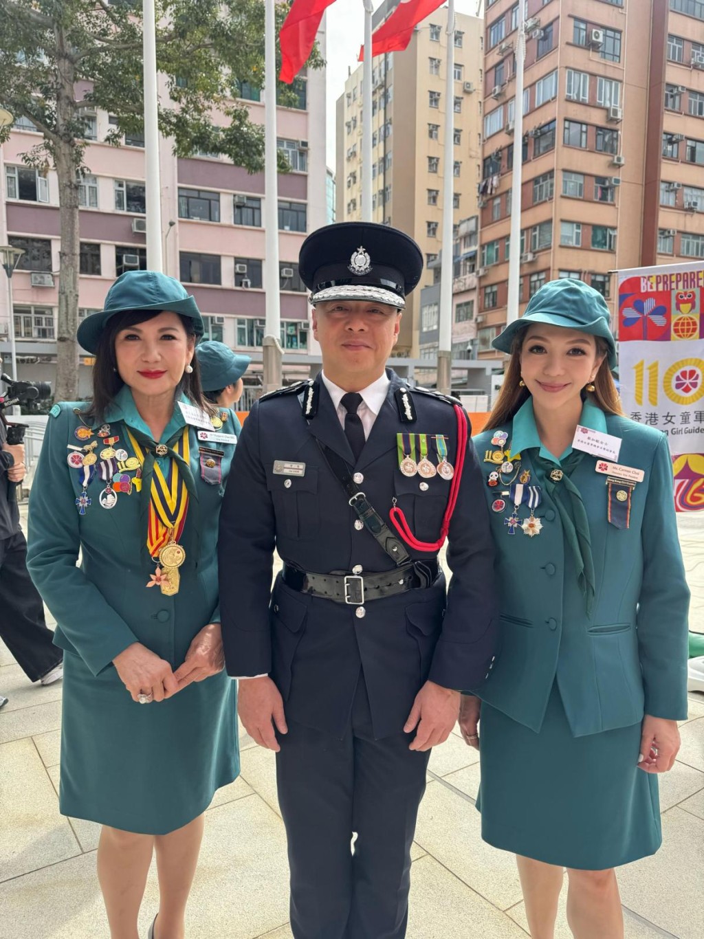 女童軍總會副會長蔡李惠莉（左）及其女兒蔡加敏（右），與警務處處長周一鳴合照。