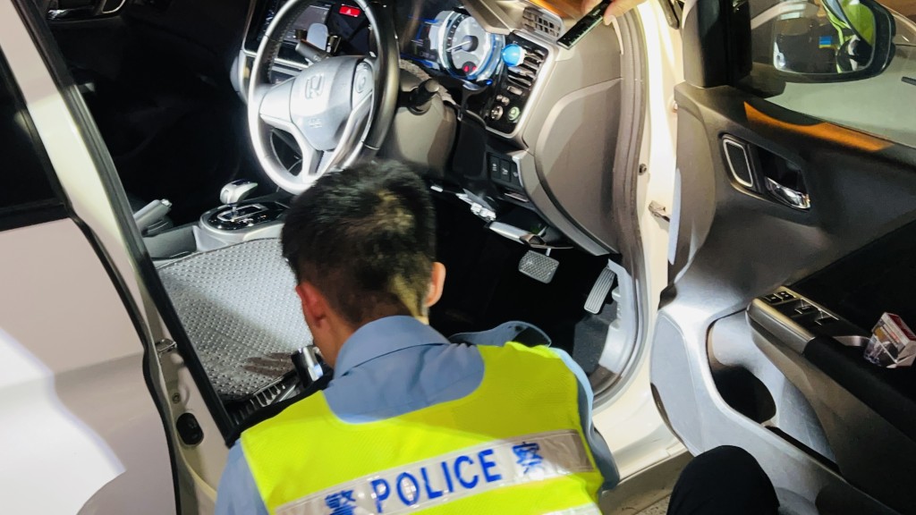 警員對私家車進行搜查。 警員對私家車進行搜查。