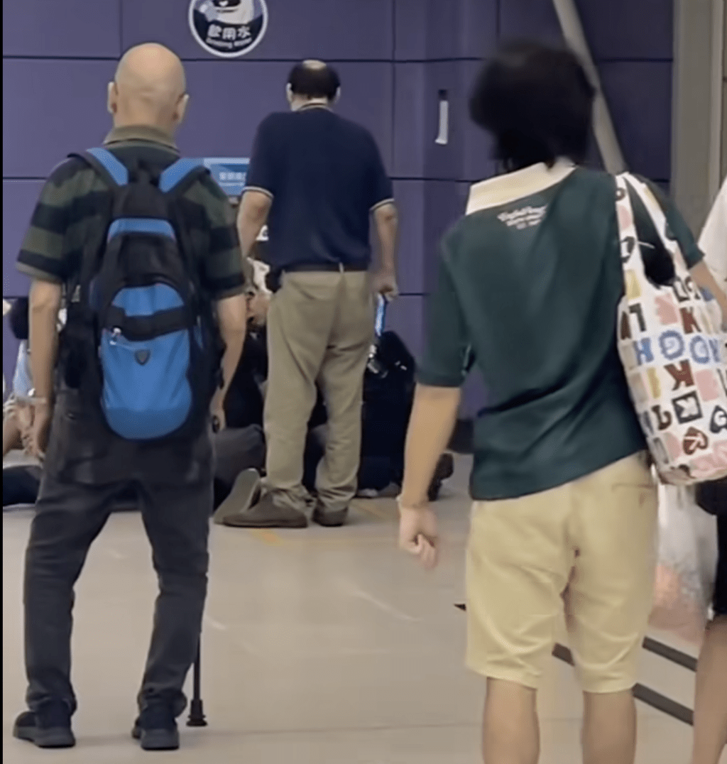 一名穿深藍色上衣的禿頭男子突然走近並高聲大罵。網上片段截圖 一名穿深藍色上衣的禿頭男子突然走近並高聲大罵。網上片段截圖