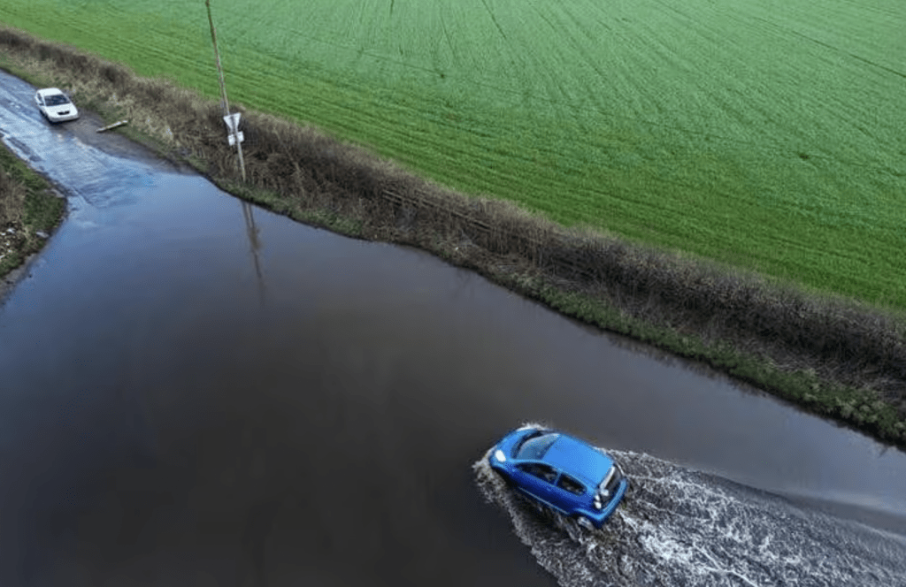 2024 年 1 月 22 日，英国斯温纳顿，一辆汽车在伊莎风暴过后驶过洪水。路透社