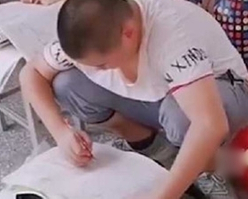 有学学生用书包当桌子做暑期作业。网图 