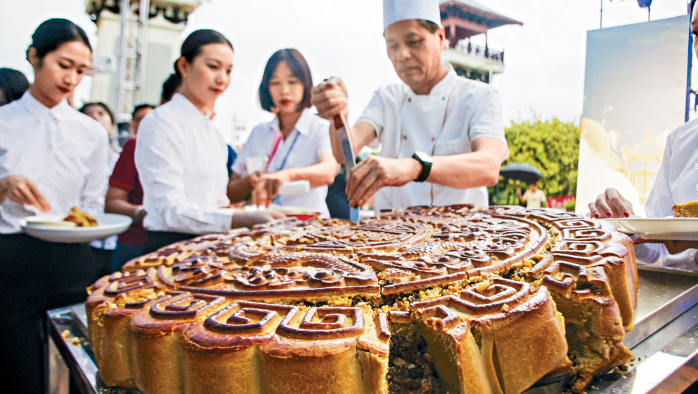 中秋將至，廣西合浦縣月餅師傅在分切大月餅。