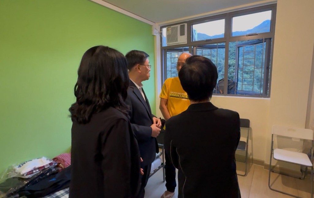 李家超（左二）到訪位於元朗的過渡性房屋項目「路德會雙魚薈」，探望及慰問早前受大埔宏福苑火災影響的災民。