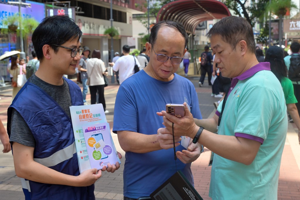 图示「智方便」流动登记队队员（右）在场协助市民登记「智方便」。政府新闻处图片