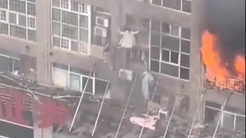 2名女子爬出窗外求生。 網片截圖