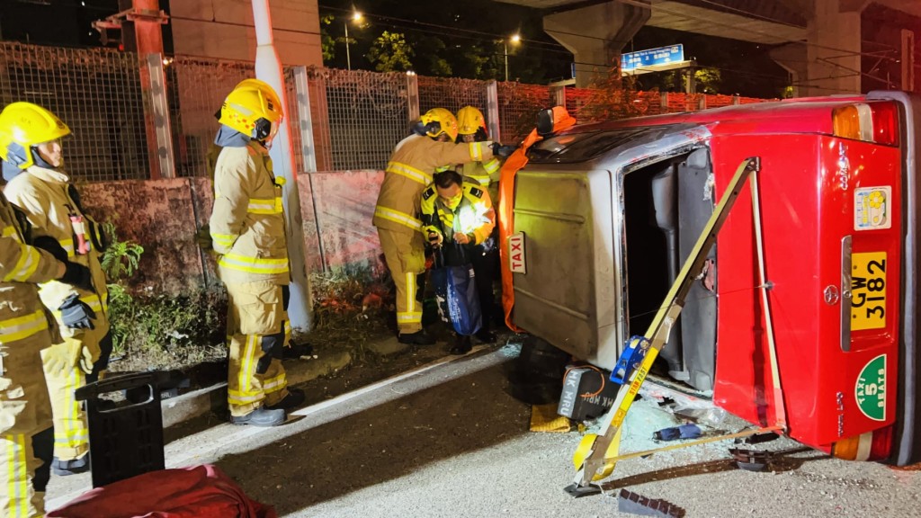 消防到場後，以鐵架支撐的士車身，並協助兩人自行爬出車廂。蔡楚輝攝