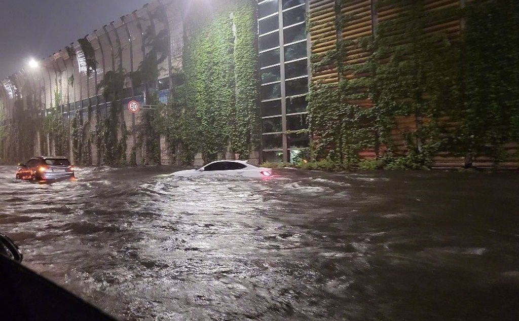 路上有汽車停在積水的馬路中間。