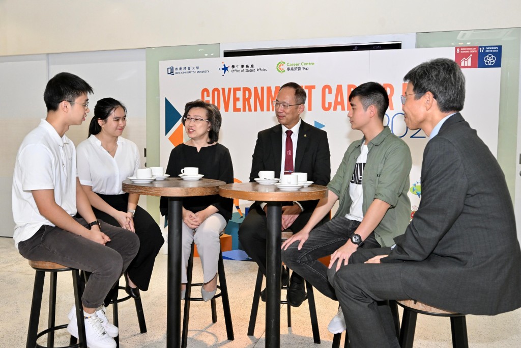 楊何蓓茵（左三）、香港浸會大學校長衞炳江（右三）在展覽與學生交談，了解他們的職業規劃和意向。政府新聞處