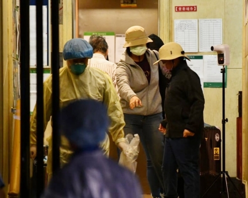 有3名文華閣居民在衛生署職員陪同下拖著行李箱離開。
