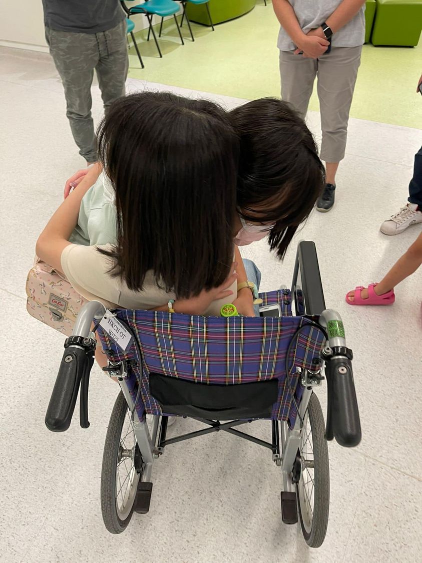 奕彤坐着轮椅跟亲友拥抱。「地上妈妈」FB图片