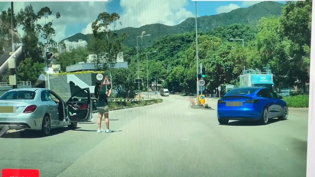 意外發生後,私家車女司機立即落車,但竟然舉起手機拍攝Tesla私家車。 意外發生後,私家車女司機立即落車,但竟然舉起手機拍攝Tesla私家車。
