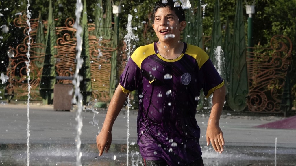 德黑蘭周二錄得攝氏38度，小朋友在易卜拉欣公園的噴泉玩水消暑。 美聯社