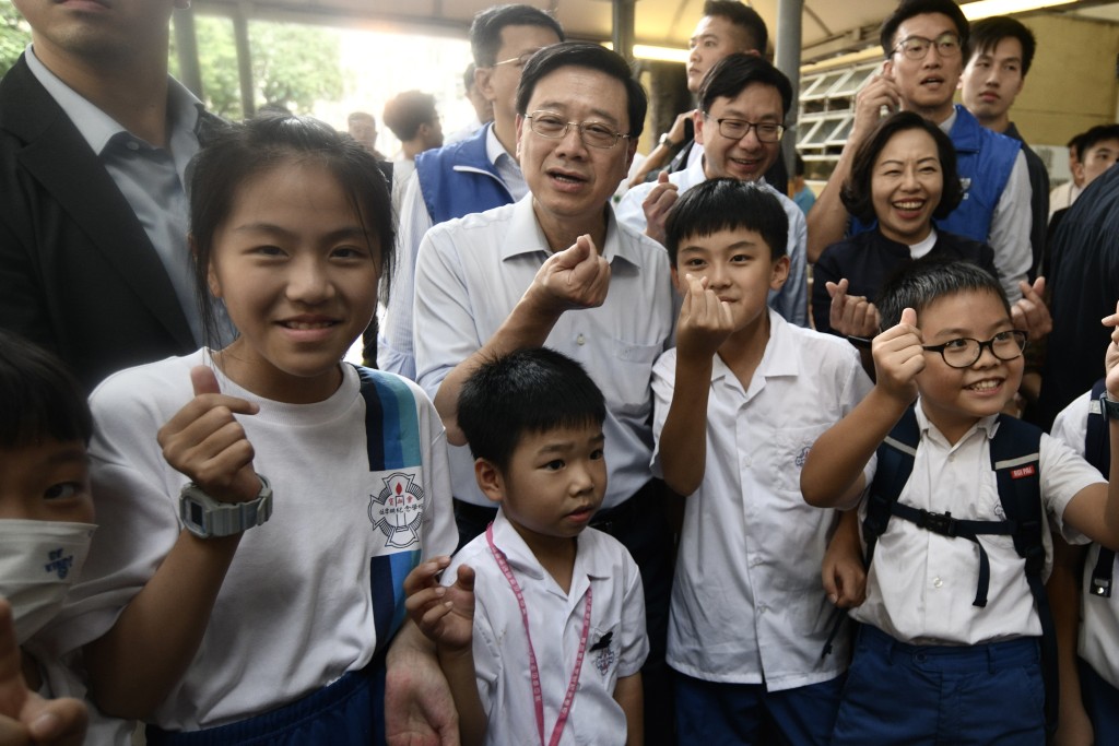 李家超早前落区，与多名小学生合照。资料图片