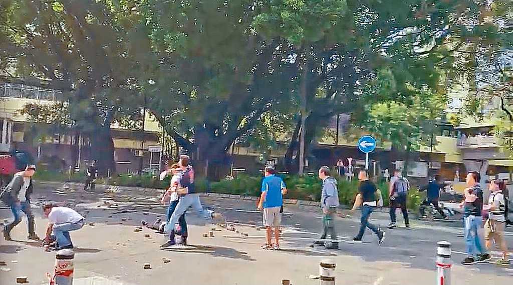 案发当日一群撑伞的蒙面人掟砖，部分市民亦掟砖还击。