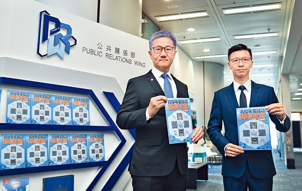 警務處處長蕭澤頤及公共關係部高級警司梁仲文手持2023年版《青少年罪行誌．師長攻略》。 