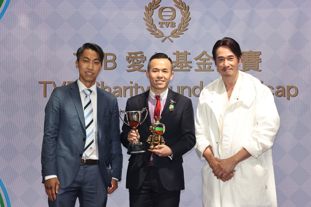 第1场「TVB爱心基金让赛」由「富存大师」胜出，并由九龙乐善堂第二副主席莫文韬先生（左）颁发奖杯、陈豪（右）致送TVBuddy予马主陈启豪（中）。  ​