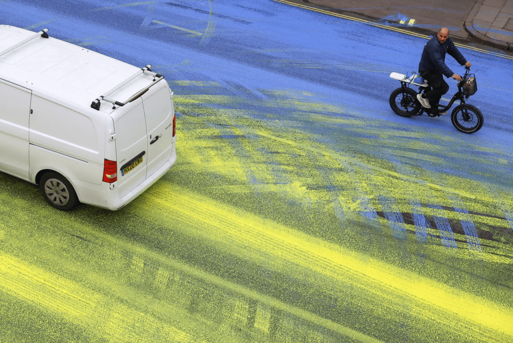隨著車流往來，藍、黃兩色油漆拖行延伸數十公尺。路透社