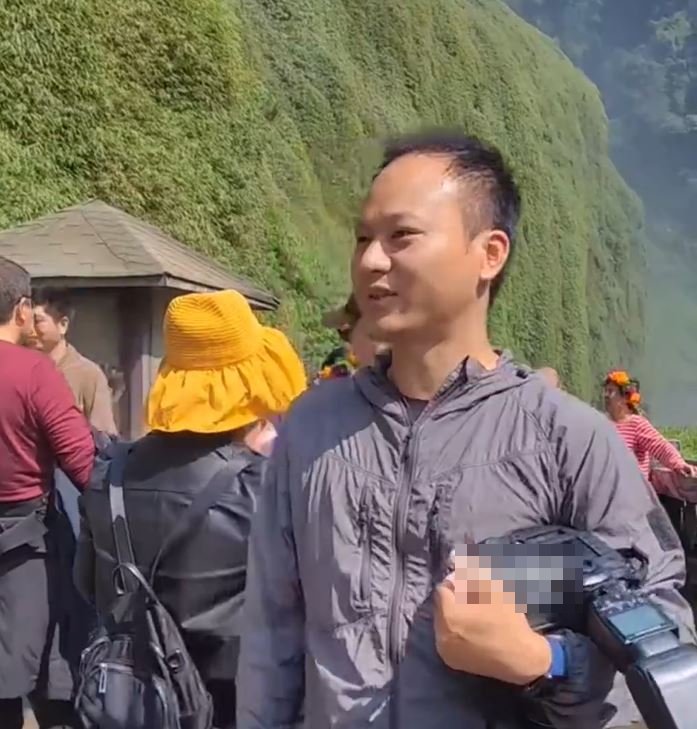 遊客在黃果樹瀑布用相機拍照。