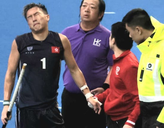 港隊球員姚祉謙（左）被對手的棍打中左手後受傷要退下火線。（陸永鴻攝）