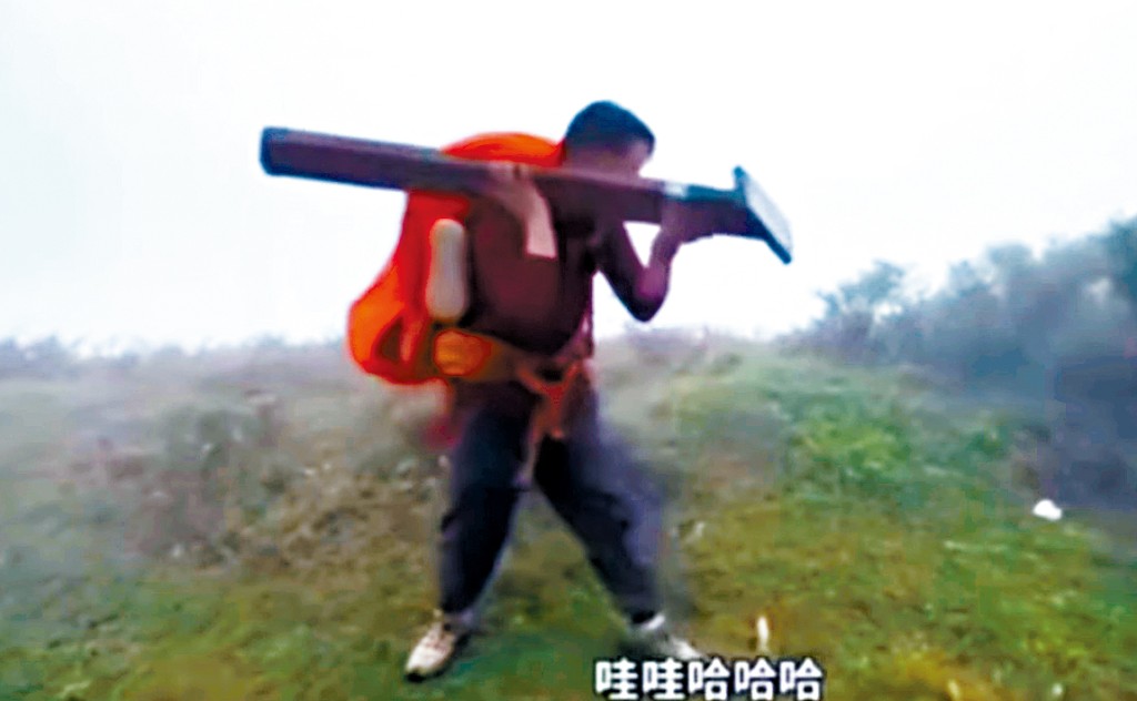 操普通話男子在大帽山麥理浩徑拔走一支標距柱,架在肩上奔跑和說笑。