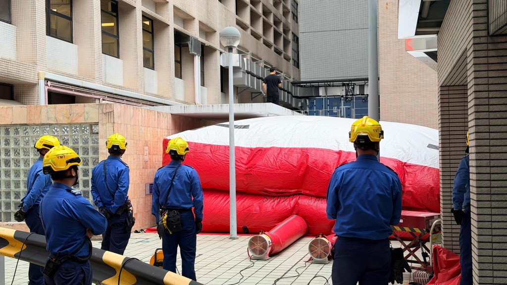 伊利沙伯醫院有男子在簷蓬危站，消防員打開氣墊戒備。梁國峰攝