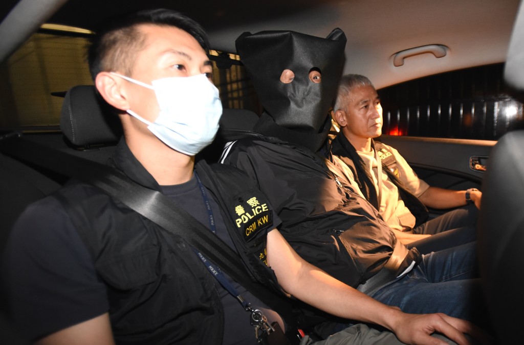 疑犯被黑布蒙頭，雙手被鎖上手銬，被押離西九龍總區警察總部。