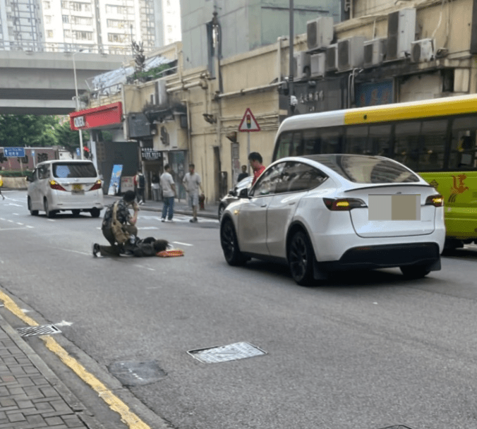 從網上圖片所見，女子倒卧路中，有男途人上前協助並撥打電話。Facebook 車cam L（香港群組）