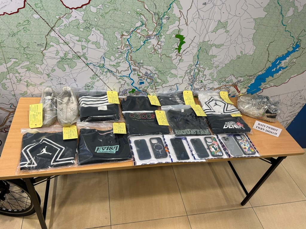 警方檢獲男童犯案時所穿衣物及其手機。曾志恒攝 警方檢獲男童犯案時所穿衣物及其手機。曾志恒攝