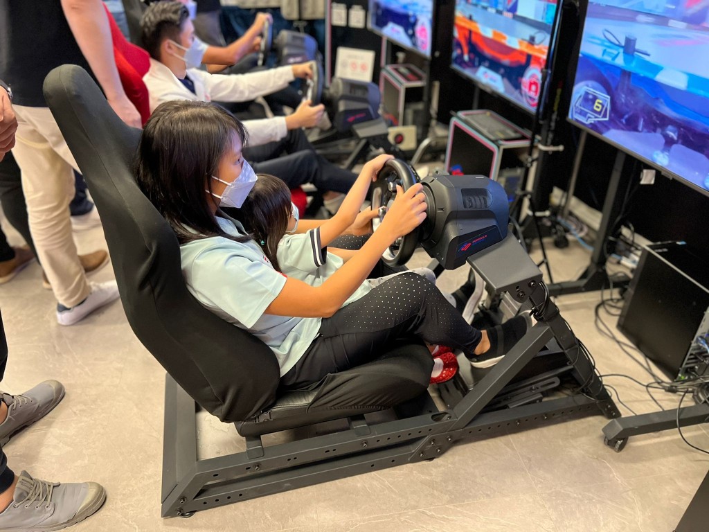 精英运动员姚洁贞（长跑）与女儿一同感受虚拟赛车。