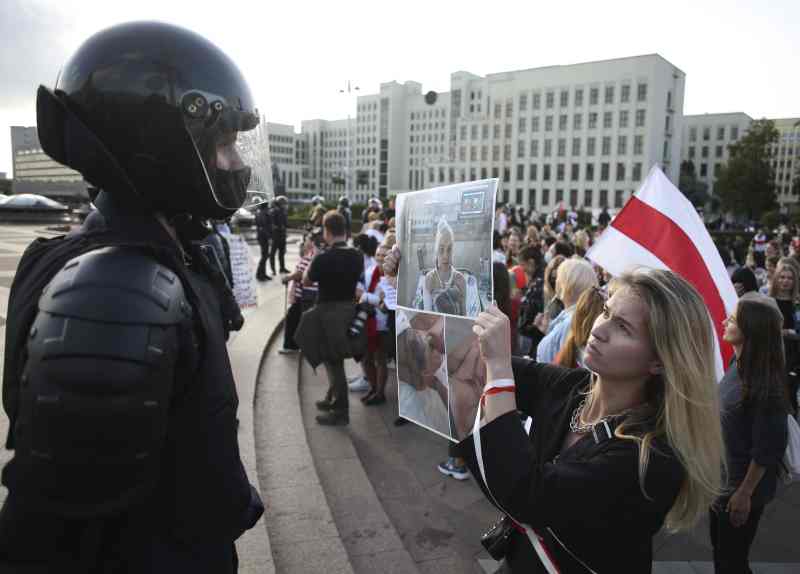 有人向在场的保安部队员展示示威者伤势的图片。AP