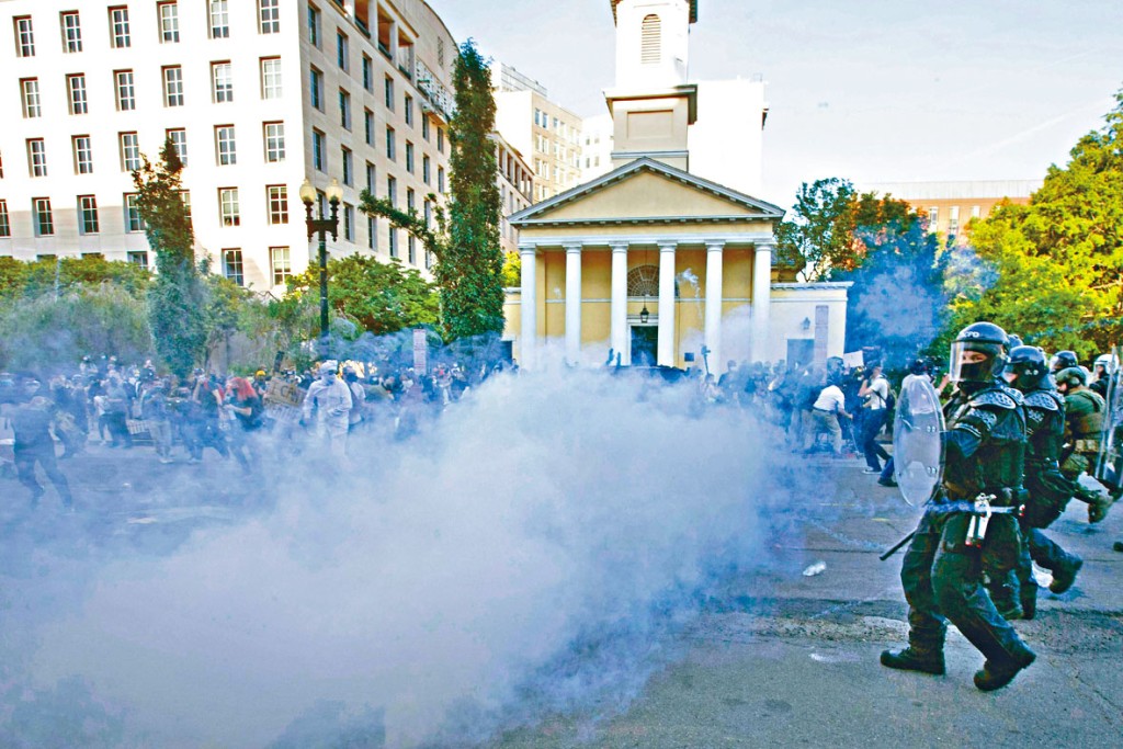 防暴警察在聖約翰公會教堂旁，發射催淚彈驅散示威者。