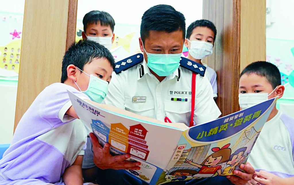 ■葵青警区指挥官谢振中总警司与学生阅读画册。