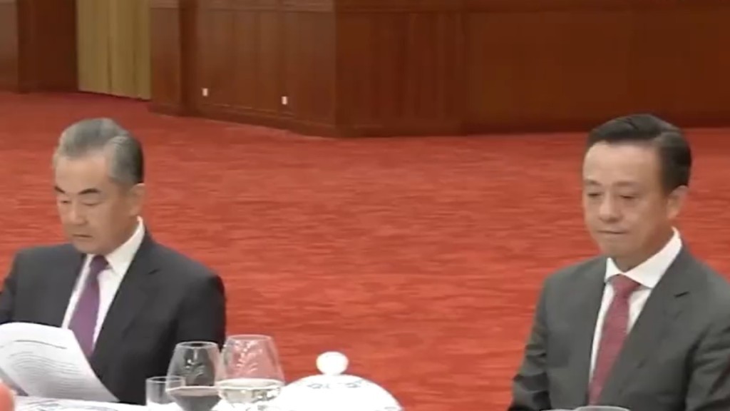 姚志胜（右）坐在政治局委员、中央外办主任王毅旁。央视