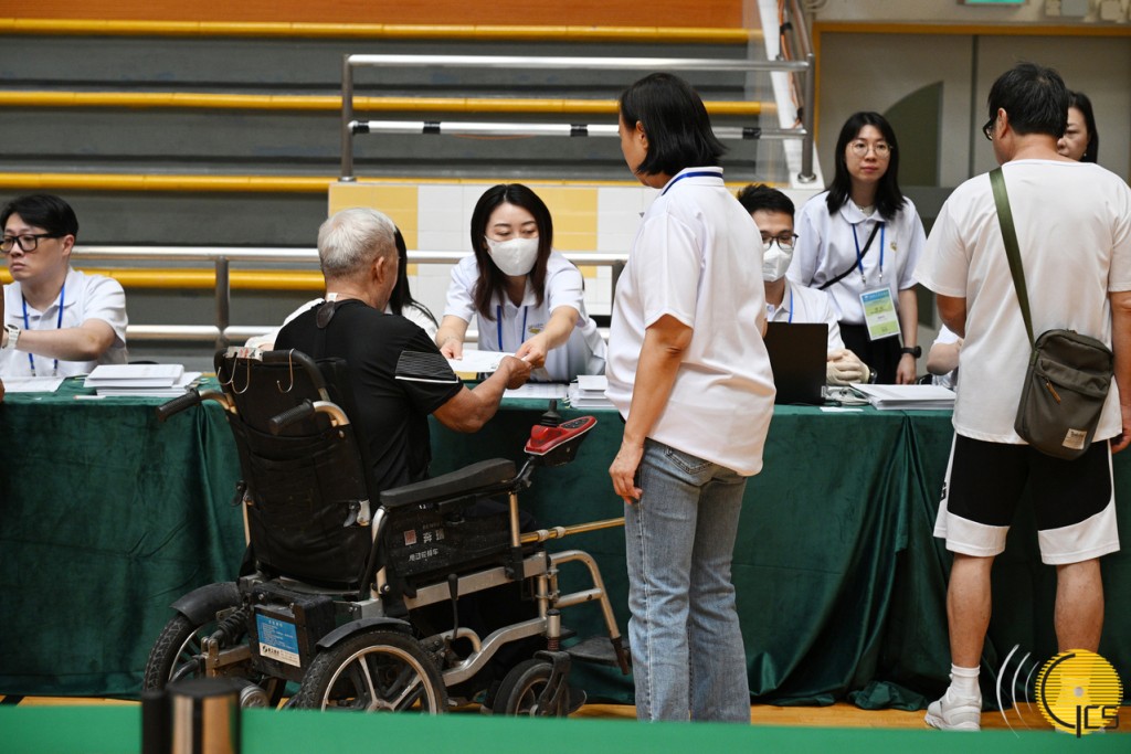澳門投票地點工作人員和投票站人員協助傷殘人士投票。澳門政府新聞局圖片 澳門投票地點工作人員和投票站人員協助傷殘人士投票。澳門政府新聞局圖片