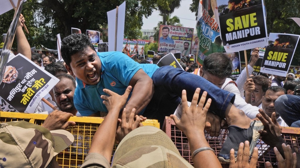 印度民众到国会外抗议曼尼普尔暴乱，有示威者被警员控制。 美联社