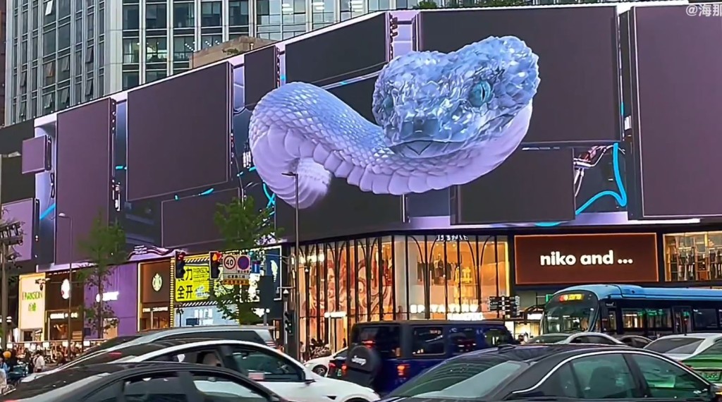 成都春熙路有商場以裸眼3D技術播出巨型藍色仿生蛇動畫成為焦點。微博＠海那個角