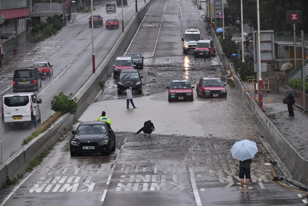 路面水浸下仍有市民外出或上班工作。陳極彰攝