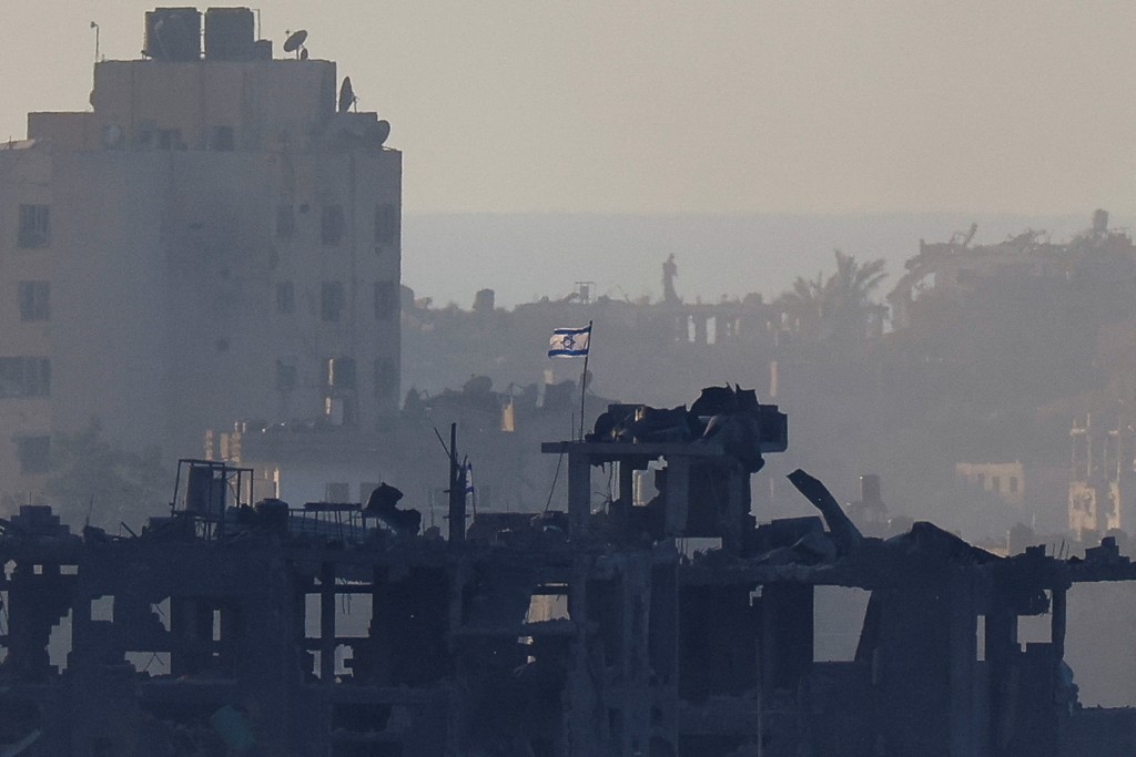 一面以色列国旗在加沙萨一栋被破坏的建筑物上飘扬。路透社