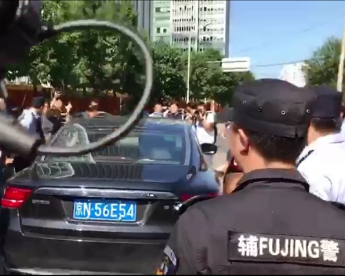 一名女子接受傳媒採訪被帶走,登上一輛私家車。張言天攝