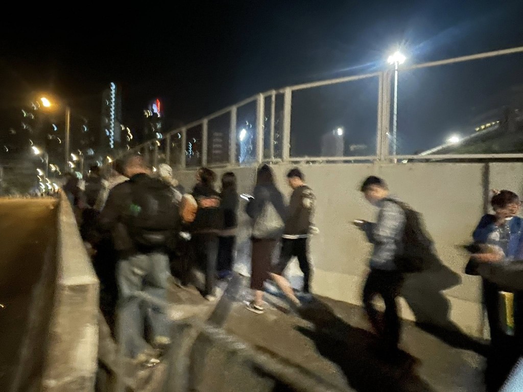 多名乘客在警方指揮下下車，沿馬路步行離開現場。FB 香港突發事故報料區及討論區 圖片