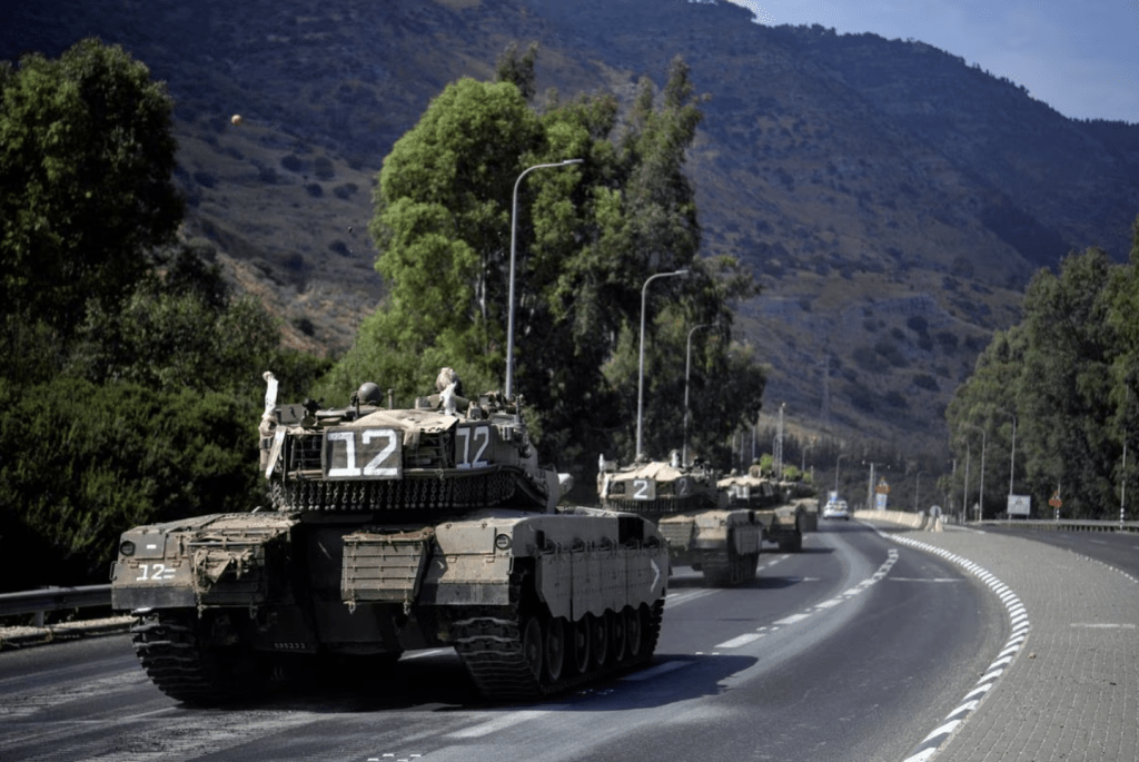 2023 年 10 月 8 日，以色列軍車車隊行駛在以色列北部靠近以色列與黎巴嫩邊境的道路上。路透社