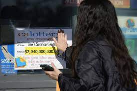 一名女子觸摸「喬伊服務中心」的廣告牌，希望沾得好運氣。 美聯社