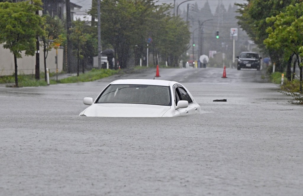 有車輛駛過水浸處幾乎被淹沒。路透社