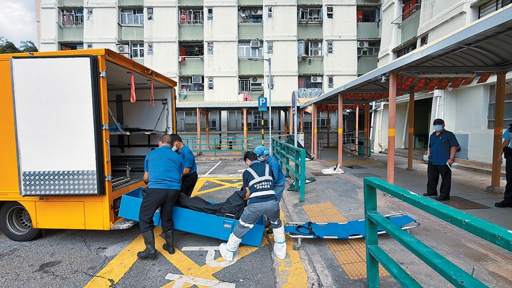 仵工將墮樓身亡夫婦的遺體運走。
