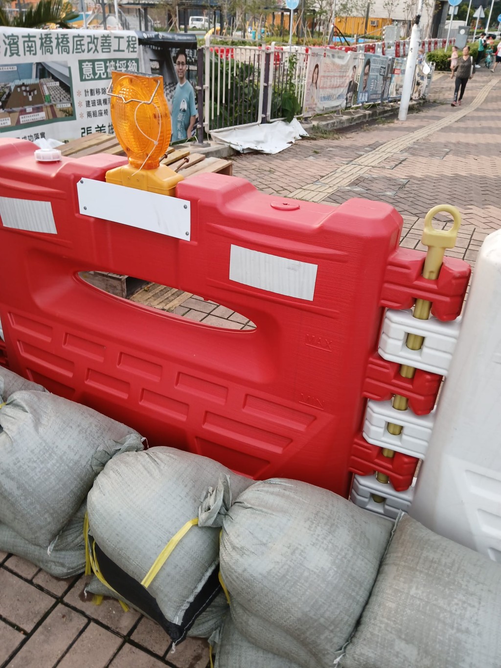超強颱風「山竹」2018年襲港時重創將軍澳 海濱長廊，如今再面對另一股超強颱風「樺 加沙」，政府與居民都嚴陣以待。  附著水馬的雙重沙包陣，已妥妥的放在兩邊 大路出入口。